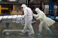  Nhân viên y tế chuyển thi thể bệnh nhân mắc COVID-19 ra nhà xác dã chiến bên ngoài một bệnh viện ở New York, Mỹ ngày 9/4/2020. (Ảnh: AFP/TTXVN)