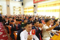 Các đại biểu biểu quyết, thông qua dự thảo Nghị quyết Đại hội Đảng bộ huyện Na Hang, tỉnh Tuyên Quang lần thứ XXII, nhiệm kỳ 2020-2025. (Ảnh: Nam Sương/TTXVN)