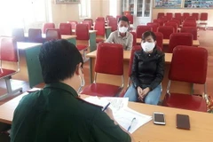 Các đối tượng có hành vi 'tổ chức cho người khác trốn đi nước ngoài trái phép' tại cơ quan điều tra. (Ảnh: TTXVN)