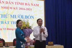 Ông Phạm Sỹ Lợi, Chủ tịch HĐND tỉnh Hà Nam tặng hoa chúc mừng bà Đinh Thị Lụa. (Ảnh: Thanh Tuấn/TTXVN)
