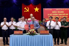 Thiếu tướng Bùi Quốc Oai, Bí thư Đảng ủy Bộ Tư lệnh Cảnh sát biển Việt Nam và ông Phạm Bạch Đằng, Phó Bí thư Thường trực Tỉnh ủy Cà Mau ký kết Chương trình phối hợp thực hiện công tác dân vận 'Cảnh sát biển đồng hành với ngư dân'' tại buỗi lễ. (Ảnh: Kim H