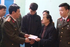 Đại tá Đào Đức Minh, Phó Giám đốc Công an tỉnh Thanh Hóa trao quà cho thân nhân gia đình các liệt sỹ. (Ảnh: Trịnh Duy Hưng/TTXVN)