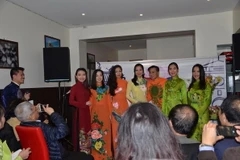 Ông Alain Vũ Đức Hoàng Mi, Chủ tịch Hội Hương sắc Việt Nam - Âu châu chụp ảnh cùng các người mẫu trình diễn thời trang áo dài. (Ảnh: Bích Hà/Vietnam+)