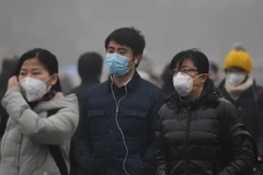 Người dân đeo khẩu trang để tránh không khí ô nhiễm tại Bắc Kinh. (Nguồn: THX/TTXVN)