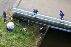 Cảnh sát điều tra tại bờ sông, nơi phát hiện ra thi thể bé Lê Thị Nhật Linh tại Abiko. (Nguồn: Kyodo/TTXVN)