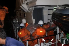 Đưa thi thể Thuyền phó Lương Văn Quỳnh về bờ. (Ảnh: Đoàn Mạnh Dương/TTXVN)