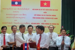 Đại diện lãnh đạo Sở Thông tin và Truyền thông tỉnh Quảng Bình và Sở Bưu điện, Viễn thông và Thông tin tỉnh Khammouane (Lào) trao Biên bản ghi nhớ hợp tác. (Ảnh: Dung Dung/TTXVN)