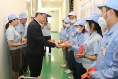 Lì xì công nhân động viên sản) xuất đầu Xuân. (Ảnh minh hoạ: Mạnh Minh/TTXVN)