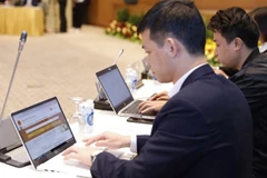 Đại diện các cá nhân, doanh nghiệp, đơn vị hành chính công trải nghiệm Cổng Dịch vụ công Quốc gia. (Ảnh: TTXVN)