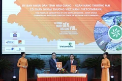 Ông Nguyễn Thanh Tùng - Phó Tổng Giám đốc phụ trách Ban điều hành Vietcombank (bên trái) và ông Đồng Văn Thanh - Chủ tịch UBND tỉnh Hậu Giang ký kết biên bản thỏa thuận hợp tác. (Ảnh: Vietnam+)