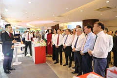 Chủ tịch UBTW MTTQ Việt Nam Đỗ Văn Chiến, Bí thư Đảng ủy Khối DNTW Nguyễn Long Hải và các đồng chí Lãnh đạo tham quan không gian trưng bày, quảng bá thương hiệu, sản phẩm dịch vụ Agribank trong khuôn khổ Hội nghị. (Ảnh: Vietnam+)