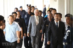 Cựu Thủ tướng Malaysia Najib Razak (giữa) rời phiên tòa ở Kuala Lumpur. (Ảnh: THX/TTXVN)