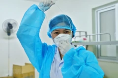 Bác sỹ chuẩn bị đồ bảo hộ vào phòng bệnh nhân COVID-19. (Ảnh: Minh Quyết/TTXVN)