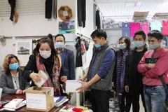 Người Việt tại Trung tâm thương mại Wólk Kosowska, Warsawa ủng hộ đồng bào miền Trung bị thiệt hại do lũ lụt. (Ảnh: Văn Long/TTXVN)