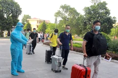 Nhân viên y tế hướng dẫn chuyên gia, lao động nước ngoài đi đường riêng khi vào khách sạn cách ly. (Ảnh: Đồng Thúy/TTXVN)