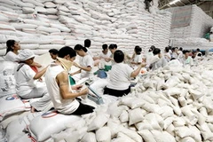 Công nhân đóng gạo nhập khẩu từ Việt Nam vào những bao nhỏ tại công ty nhập khẩu gạo Philippines. (Ảnh: AFP/TTXVN)