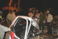 Hiện trường vụ tai nạn và lực lượng cứu hộ đang khẩn trương đưa thi thể các nạn nhân ra khỏi xe. (Ảnh Văn Sơn/TTXVN)