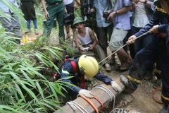 Tìm kiếm 3 phu vàng bị kẹt dưới hang sâu do mưa lớn. (Ảnh: Trịnh Duy Hưng/TTXVN)