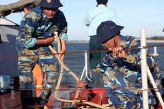 Chiến sỹ tàu HQ221 tháo dây neo tàu lên đường đi cứu nạn. (Ảnh: Thanh Tùng/TTXVN)