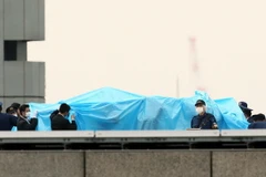 Cảnh sát kiểm tra vật thể bay được phát hiện trên nóc Văn phòng Thủ tướng Nhật. (Ảnh: AFP/TTXVN phát)