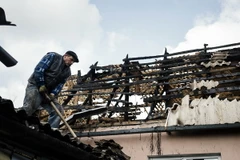 Người dân địa phương sửa chữa căn nhà bị đổ nát trong xung đột tại Donetsk ngày 6/4. (Nguồn: AFP/TTXVN)