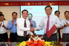 Tổng Giám đốc Thông tấn xã Việt Nam Nguyễn Đức Lợi (bên trái) ký kết với Tổng Thanh tra Chính phủ Huỳnh Phong Tranh. (Ảnh: Quý Trung/TTXVN)