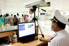 Kiểm tra nhiệt độ hành khách bằng máy đo thân nhiệt tia hồng ngoại tại sân bay Nội Bài. (Ảnh: Dương Ngọc/TTXVN)