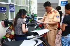 Công an quận Hai Bà Trưng, Hà Nội làm thủ tục đăng ký đăng ký xe môtô điện, xe máy điện cho nhân dân trước ngày 1/7/2016. (Ảnh: Doãn Tấn/TTXVN)