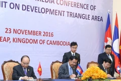 Thủ tướng Nguyễn Xuân Phúc, Thủ tướng Campuchia Samdech Hun Sen và Thủ tướng Lào Thongloun Sisoulith ký Tuyên bố chung Hội nghị CLV9. (Ảnh: Thống Nhất/TTXVN)