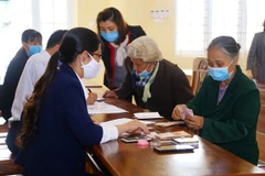 Chi trả tiền hỗ trợ cho các đối tượng nhận hỗ trợ khó khăn do dịch bệnh COVID-19. (Ảnh: PV/Vietnam+)