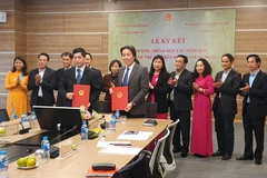 Ký kết chương trình hợp tác bảo vệ trẻ em trên không gian mạng. (Ảnh: PV/Vietnam+)