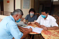 Chi trả tiền hỗ trợ cho người dân gặp khó khăn vì COVID-19. (Ảnh: TTXVN)