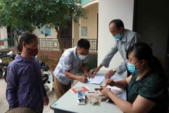 Chi trả tiền hỗ trợ cho hộ nghèo. (Ảnh minh họa: Hoàng Hùng/TTXVN)