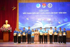 Ban tổ chức tặng sách cho các sinh viên tại diễn đàn. (Ảnh: PV/Vietnam+)
