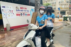 Hoa hậu Tiểu Vy và Á hậu Ngọc Thảo làm 'shipper' đi trao các suất ăn cho lực lượng đầu chống dịch. (Ảnh: CTV/Vietnam+)
