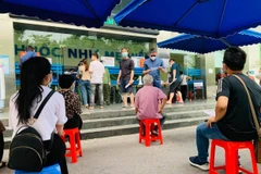 Người dân Thủ đô xếp hàng chờ tiêm chủng COVID-19. (Ảnh minh họa: M.Mai/Vietnam+)