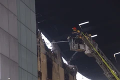 Cảnh sát phòng cháy chữa cháy tiếp cận hiện trường dập lửa hôm 27/3. (Ảnh: Thanh Liêm/TTXVN)