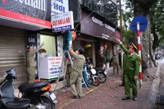 Lực lượng chức năng quận Hai Bà Trưng ra quân xử lý các hành vi lấn chiếm vỉa hè, lòng đường tại phố Hàn Thuyên. (Ảnh: Doãn Tấn/TTXVN)