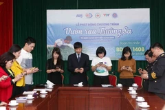 Các đại biểu nhắn tin ủng hộ Chương trình tại buổi lễ. (Ảnh: Quý Trung/TTXVN)