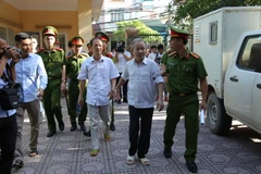 Dẫn giải bị cáo Bạch Văn Đông và Nguyễn Tiến Triển vào phòng xét xử. (Ảnh: Nguyễn Văn Cảnh/TTXVN)