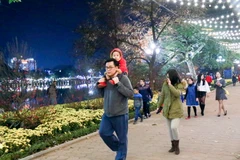 Người dân dạo chơi bên bờ hồ Hoàn Kiếm, Hà Nội. (Ảnh: Đắc Giang/TTXVN phát)