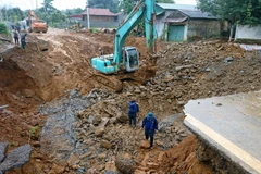 Chính quyền địa phương đã khẩn cấp huy đọng các lực lượng giúp 5 hộ dân cạnh hỗ cáttơ di dời lên vị trí an toàn. (Ảnh: Quang Duy/TTXVN)