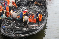 Lực lượng tìm kiếm và cứu hộ làm nhiệm vụ trên chiếc phà bị cháy ngày 1/1/2017. (Nguồn: EPA/TTXVN)