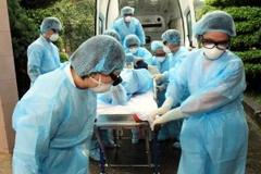 Cán bộ y tế chuyển bệnh nhân nghi mắc cúm A (H7N9) tới khu điều trị cách ly. (Ảnh: Thái Thuần/TTXVN)