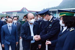 Chủ tịch nước Nguyễn Xuân Phúc với cán bộ, chiến sỹ lực lượng chức năng làm nhiệm vụ tại Cửa khẩu quốc tế Hữu Nghị. (Ảnh: Thống Nhất/TTXVN)