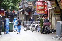 Lực lượng công nhân vệ sinh thu dọn rác thải tại khu vực phong tỏa phường Phú Đô, quận Nam Từ Liêm (Hà Nội). (Ảnh: Tuấn Đức/TTXVN)
