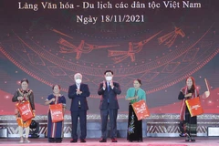 Chủ tịch Quốc hội Vương Đình Huệ và Chủ tịch Ủy ban Trung ương Mặt trận Tổ quốc Việt Nam Đỗ Văn Chiến trao quà cho các đại biểu dân tộc tại Làng Văn hóa. (Ảnh: Doãn Tấn/TTXVN)