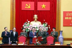 Bộ trưởng Bộ Công an Tô Lâm và Bộ trưởng Bộ Thông tin và Truyền thông Nguyễn Mạnh Hùng ký Quy chế phối hợp giữa 2 đơn vị. (Ảnh: Phạm Kiên/TTXVN)