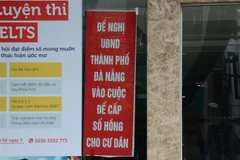 Cư dân chung cư F.Home treo băngrôn trước tòa nhà để kiến nghị chính quyền xử lý vụ việc. (Ảnh: Quốc Dũng/TTXVN)