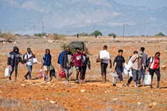 Người di cư rời trại tị nạn Pournara ở CH Cyprus. (Ảnh: AFP/TTXVN)